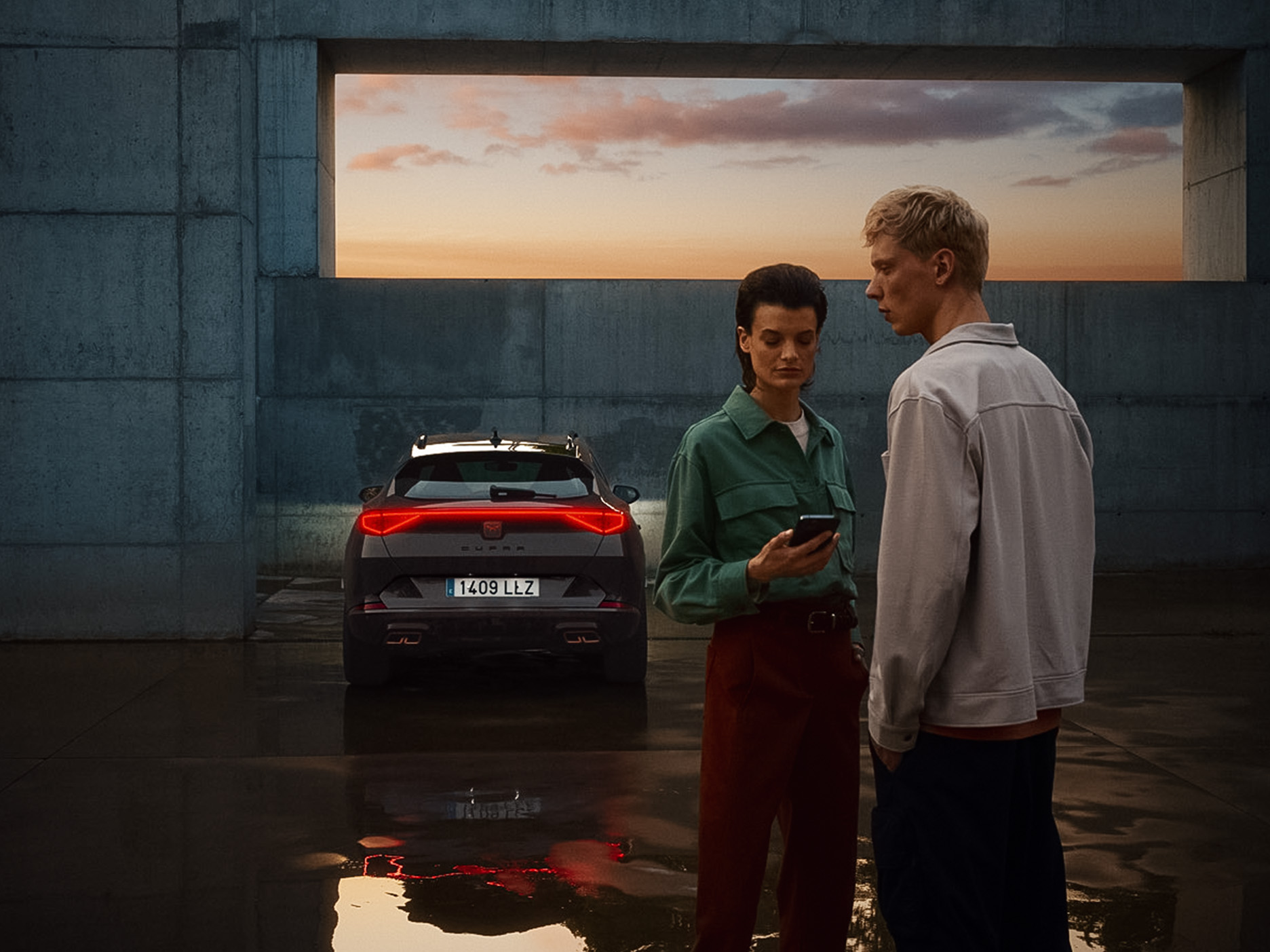 CUPRA Formento three quarter rear design parked in an outdoors setting, with the city’s skyline in the background.