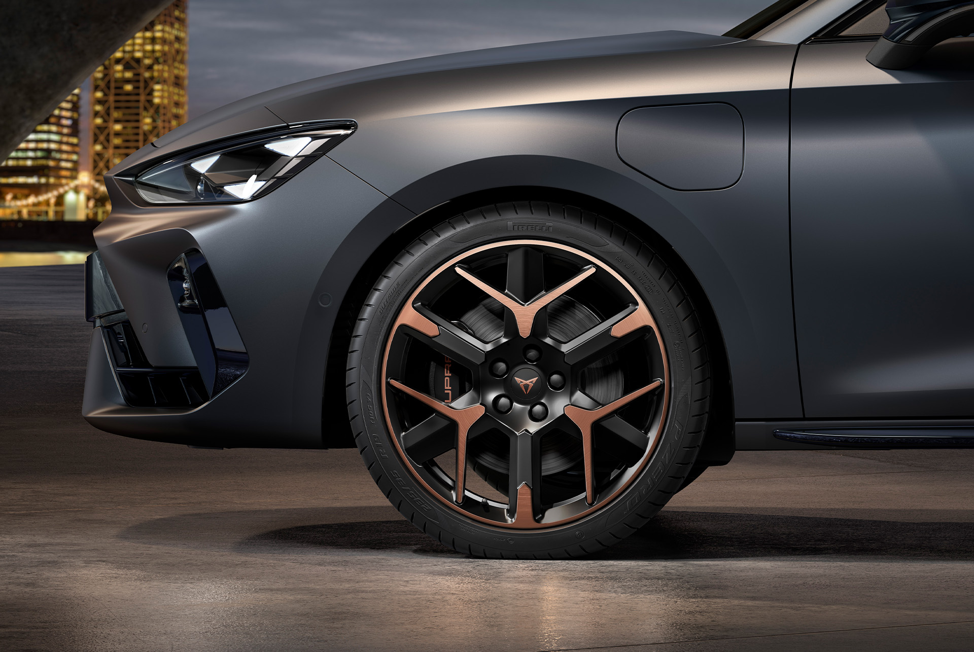 front side view of left forged alloy wheel in copper and black for the cupra leon Sportstourer, tyres, signature headlights and grey body