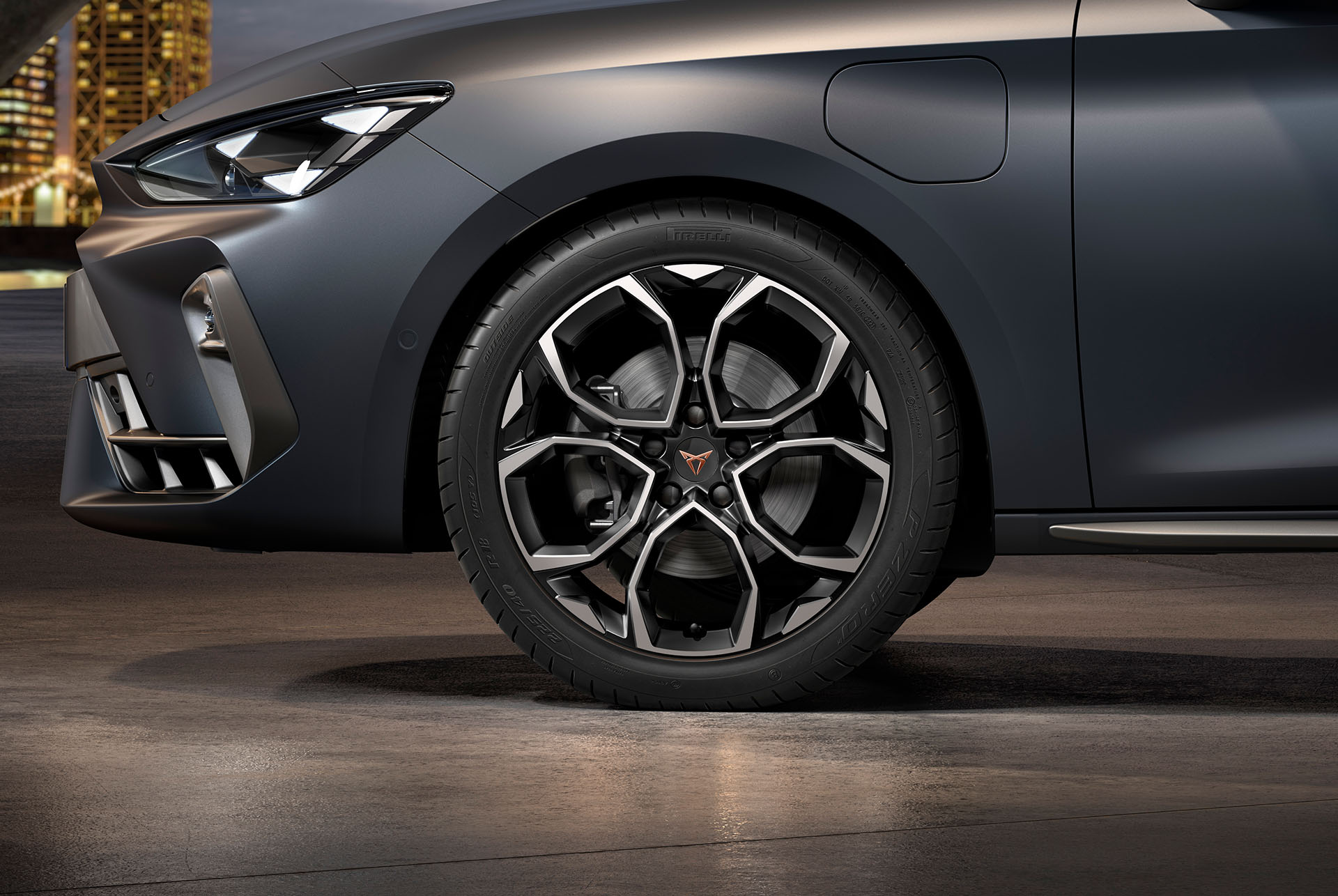 front side view of left machined silver and black windstorm alloy wheel for the cupra leon Sportstourer, tyres, signature headlights and grey body