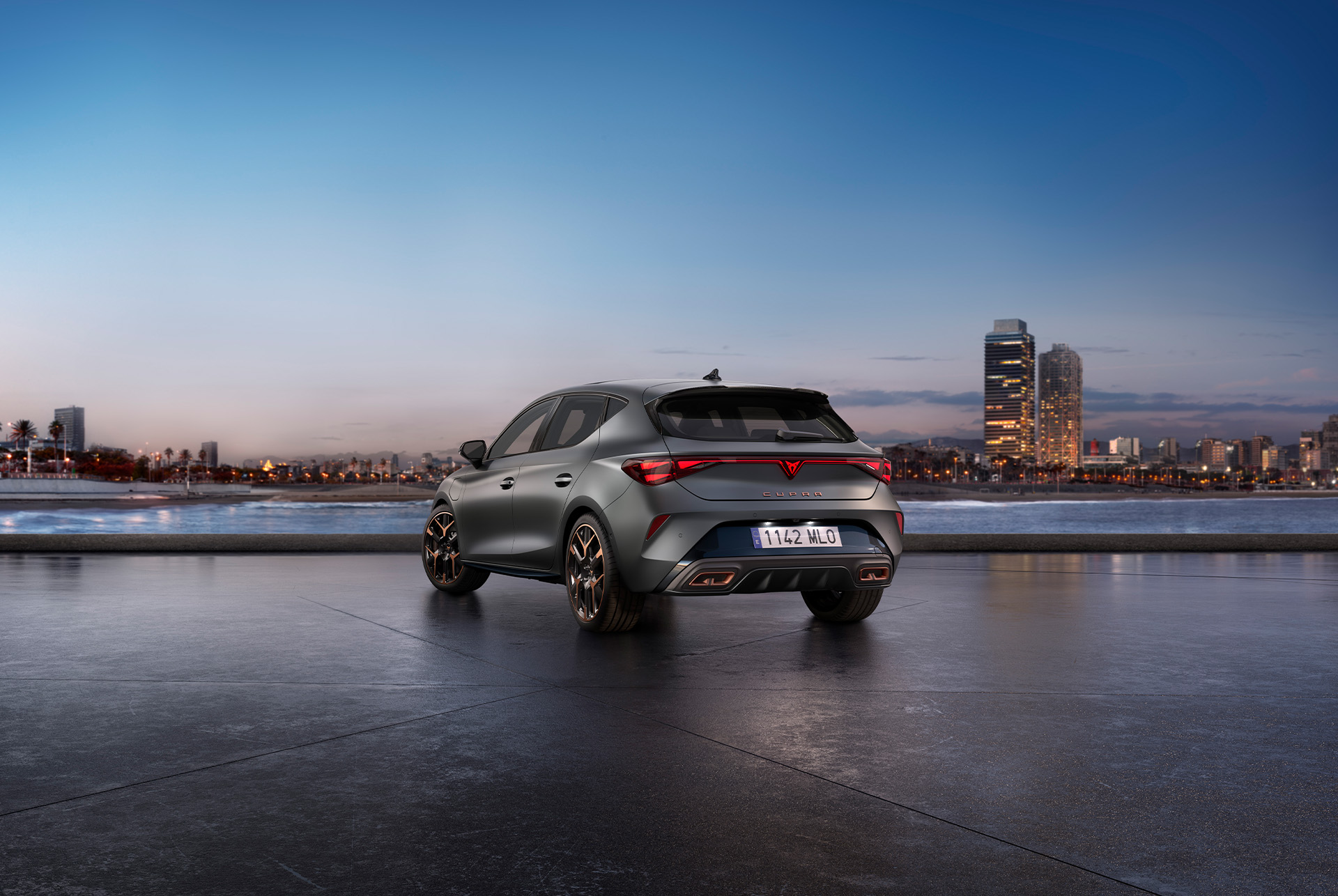 rear view shot of the cupra leon in grey parked in a diaphanous, urban setting at sunset.