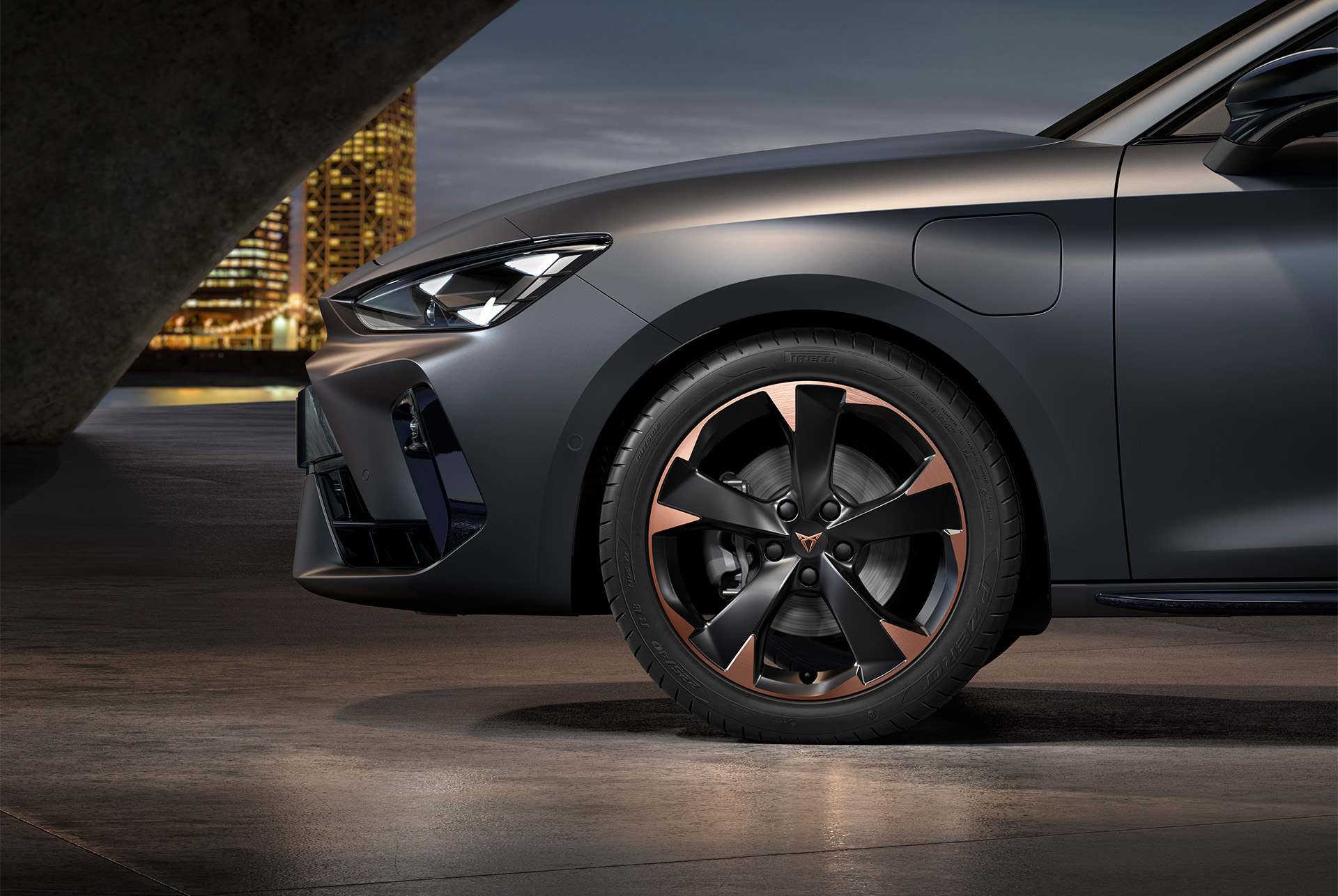front side view of left mistral garbi copper machined alloy wheels for the Cupra Leon, tyres, signature headlights and matt grey body.
