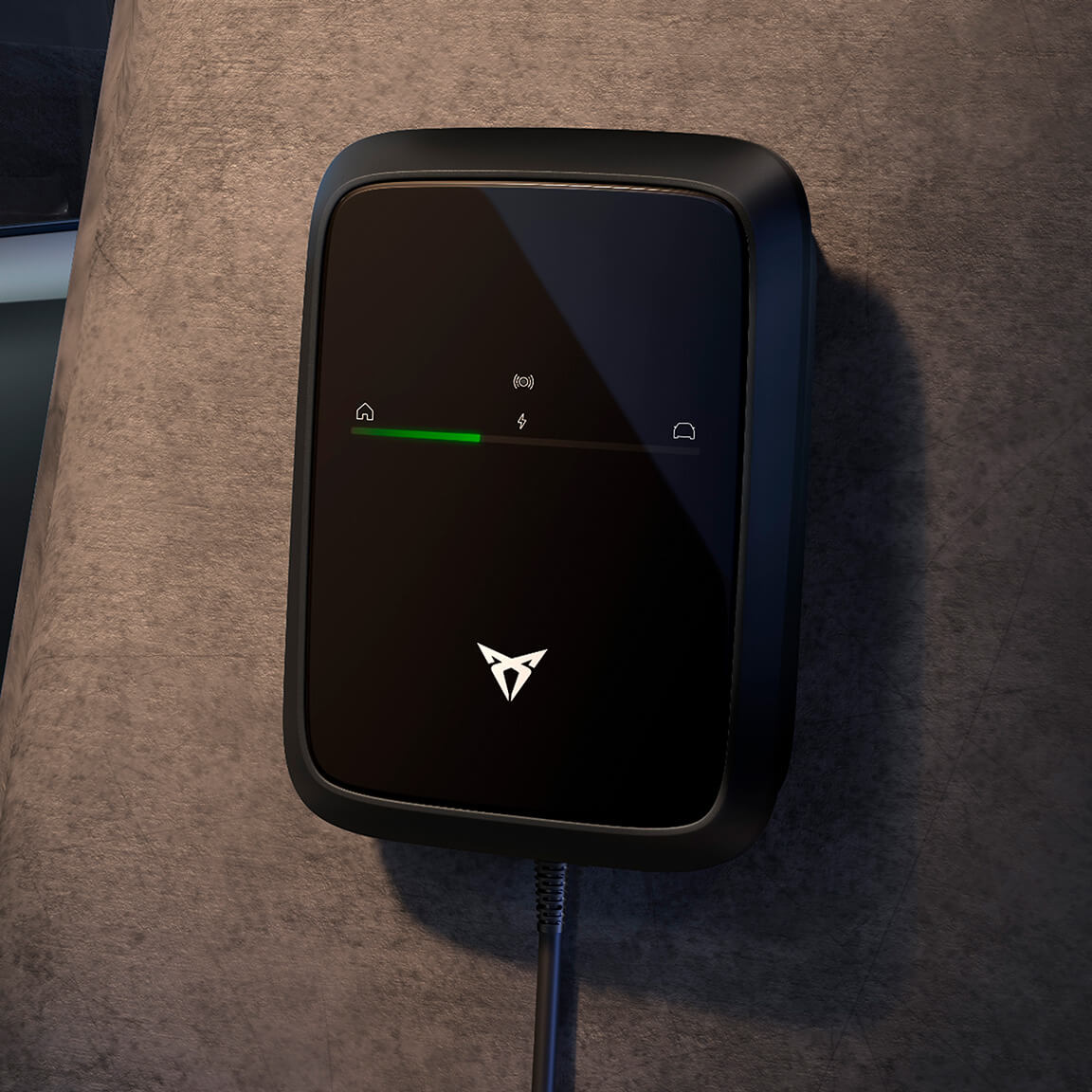 A close-up of a sleek, black electric car wall charger mounted on a gray wall. The charger features the white CUPRA logo and a green indicator light showing the charging status.