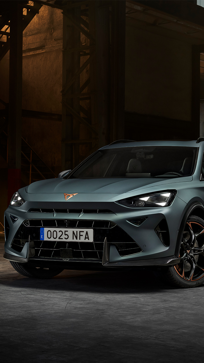 A woman in a light green jumpsuit and dark sneakers appearing to float in a seated position on a city street at night, with a modern glass building in the background.